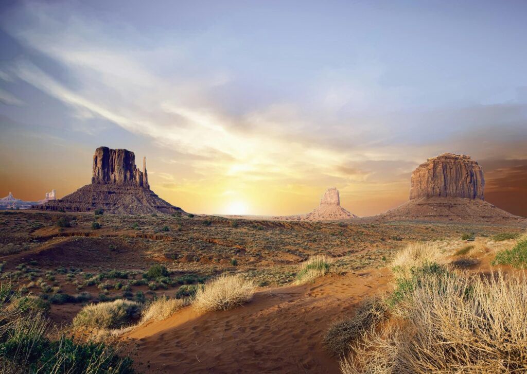 Breathtaking view of Monument Valley's iconic rock formations at sunset, showcasing vivid desert landscape.